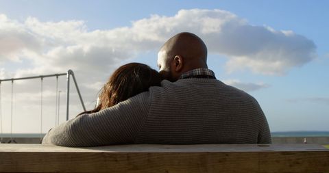 Couple Relaxing on Park Bench with Scenic Sky Background