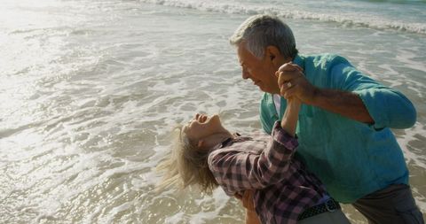 Senior Couple Enjoying Dance on Sunlit Beach