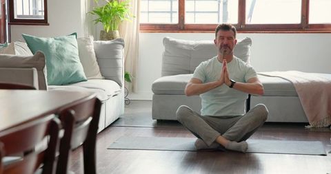 Man Meditating in Modern Living Room for Relaxation and Mindfulness
