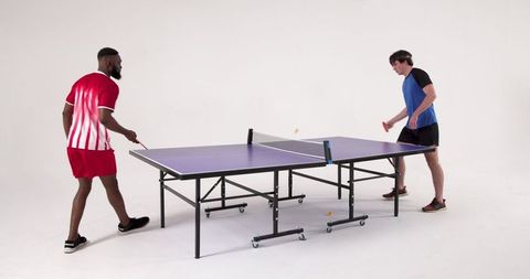 Men competing intensely in table tennis match