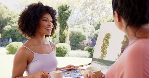Women Painting in Park Enjoying Coffee and Conversation