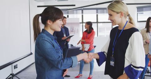 Diverse Female Colleagues Shaking Hands at Office Meeting