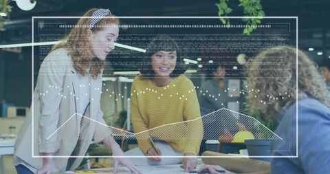 Designers collaborating over sketches with analytics overlay in modern open-plan workspace