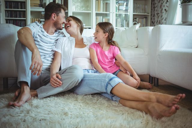 Happy family sitting on the rug in living room at home