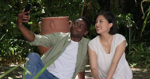 Happy Friends Taking Selfies in Lush Garden Environment