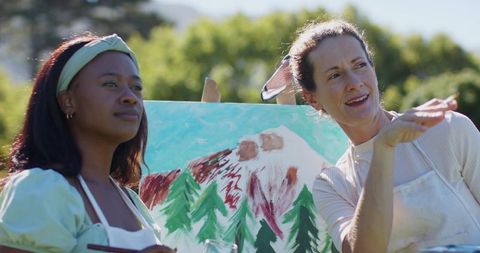 Diverse Women Friends Painting Landscape in Sunlit Garden