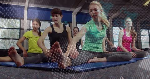 Women Stretching on Mats in Fitness Class Focusing on Vitality