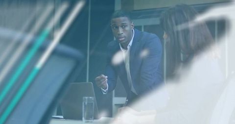 African American executive leading strategic presentation in modern glass boardroom