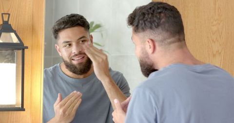 Man Applying Skincare Lotion in Modern Minimalist Bathroom