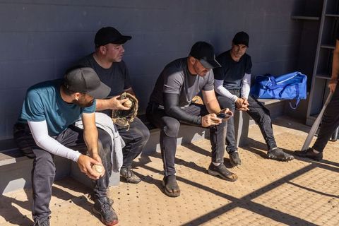 Baseball teammates relaxing in dugout during game break