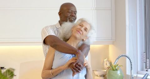 Joyful Senior Couple Embracing in Bright Cozy Kitchen