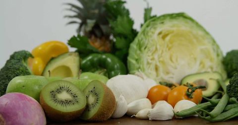 Variety of fresh vegetables and fruits on wooden surface