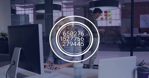 Female professional typing at open-plan desk with digital data overlay in modern office
