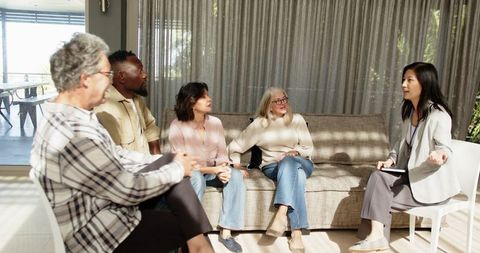 Group therapy session with diverse participants in warm setting