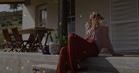 Woman Relaxing on Porch Under Warm Sunlight