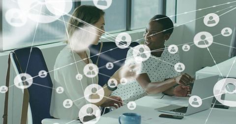 Coworkers Discussing Project on Laptop with Network Overlay in Modern Office Collaboration