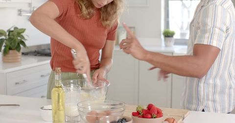 Couple Collaborating to Whisk Batter in Modern Kitchen