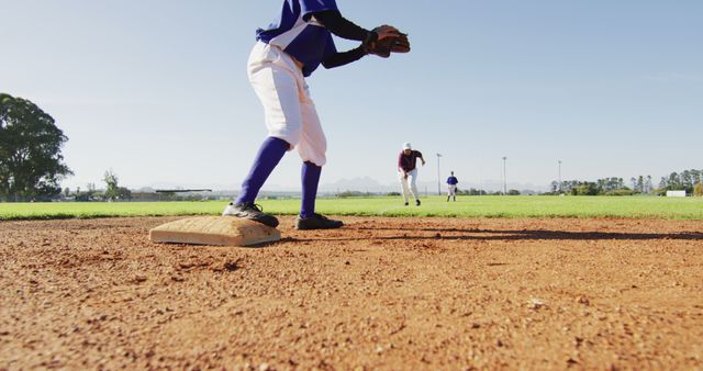 Diverse female baseball players, fielder on base catching out a running hitter on baseball field. female baseball team, sports training and game tactics.
