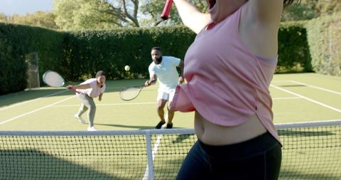 Friends Enjoying Outdoor Tennis Match in Sunny Park