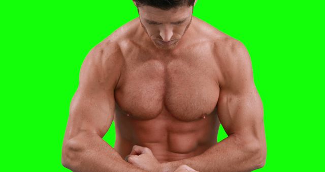 Male bodybuilder posing in front of green screen, highlighting well-defined muscles and physique. Useful for fitness and health promotions, gym advertisements, personal training and workout motivation content.