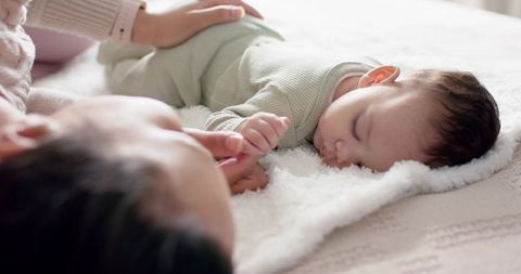 Mother Holding Infant’s Hand in Warm Bonding Moment