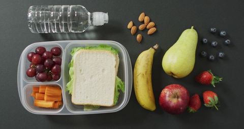 Healthy packed lunch with fruits veggies and sandwich