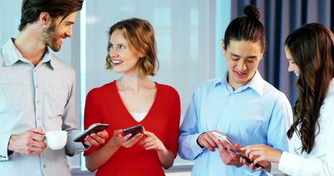 Diverse Colleagues Collaborating with Smartphones in Modern Office - Download Free Stock Images Pikwizard.com
