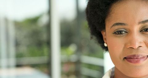 Elegant African American Woman Relaxing by Glass Door