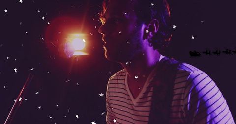Musician Performing on Dimly Lit Stage with Microphone