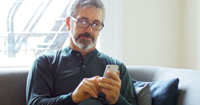 Older Man in Glasses using Smartphone on Couch - Download Free Stock Images Pikwizard.com