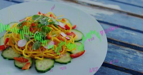 Colorful spiral noodles with fresh vegetables on blue table