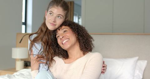 Loving Female Couple Embracing in Cozy Bedroom Setting