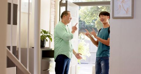 Father and Son Smiling and Pointing at Home Entryway