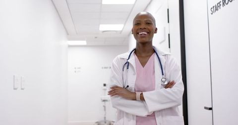 Smiling African Female Doctor Standing Confidently in Bright Clinic Corridor