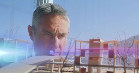 Architect analyzing architectural model with creative lens flare