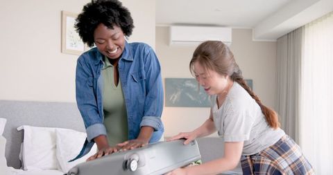 Interracial Lesbian Couple Packing Luggage for Summer Vacation