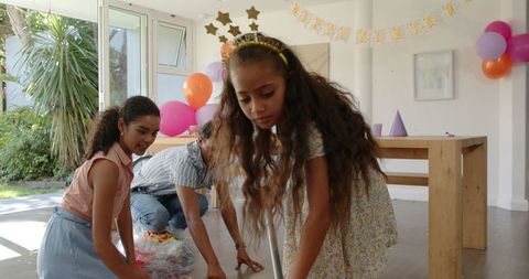 Family Cleaning Up After Bright and Colorful Kids Birthday Party