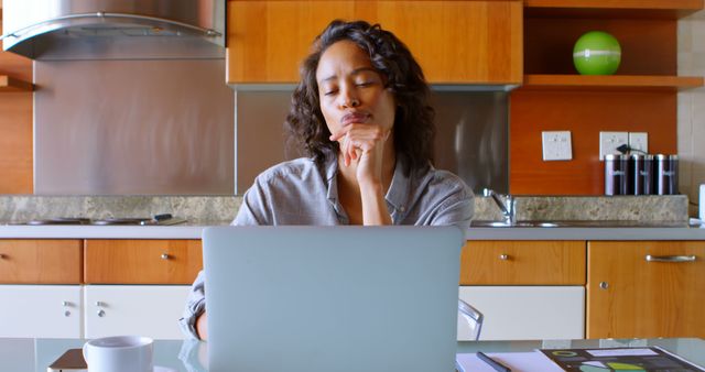 Pensive Woman Working at Home Kitchen Table with Laptop and Coffee - Download Free Stock Images Pikwizard.com