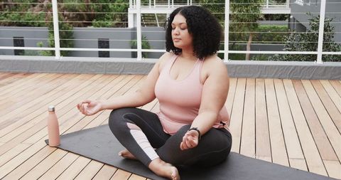 Plus Size Woman Meditating on Rooftop Deck Practicing Mindfulness and Yoga