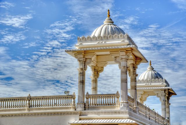 Intricate white marble temple showcasing detailed architecture with cloudy sky in background, suitable for depicting cultural heritage, travel destinations, architectural studies, religious significance, and historical documentation.