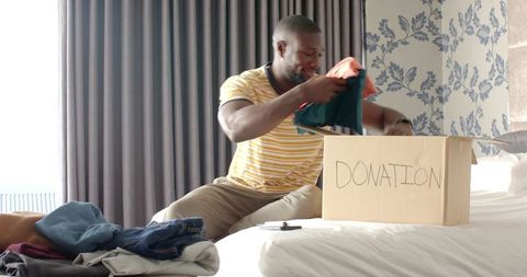 Man donating clothes thoughtfully organizing wardrobe donation