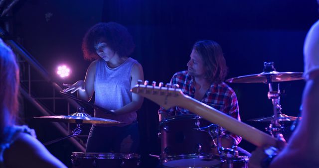 Diverse band performing on stage with vibrant blue lighting - Download Free Stock Images Pikwizard.com