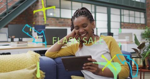 Young woman engaging with flash sale on tablet in modern office