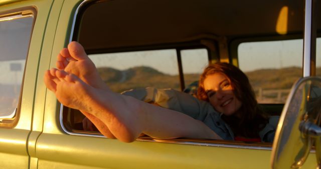 Woman legs out of the van window during sunset. Woman relaxing in van 4k