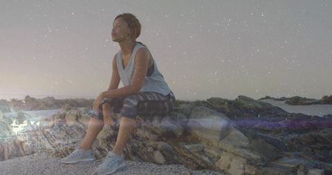 Woman Meditates on Coastal Rocks Representing Tranquility and Fitness