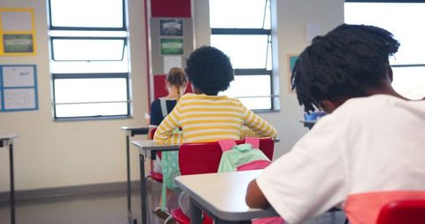 Focused students working at desks in bright classroom