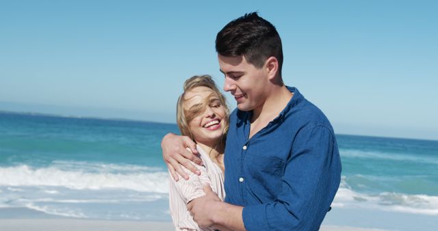 Happy couple embracing on sandy beach with ocean backdrop - Download Free Stock Images Pikwizard.com