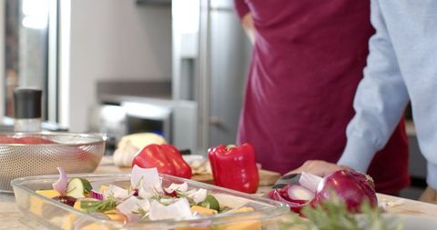 Friends Preparing Fresh Vegetable Salad in Home Kitchen Together
