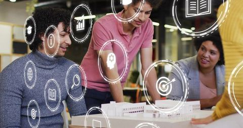 Team collaborating over architectural scale model with augmented reality icons for design presentati
