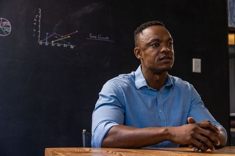 Professionally Dressed Man Analyzing Chalk Diagrams in Office